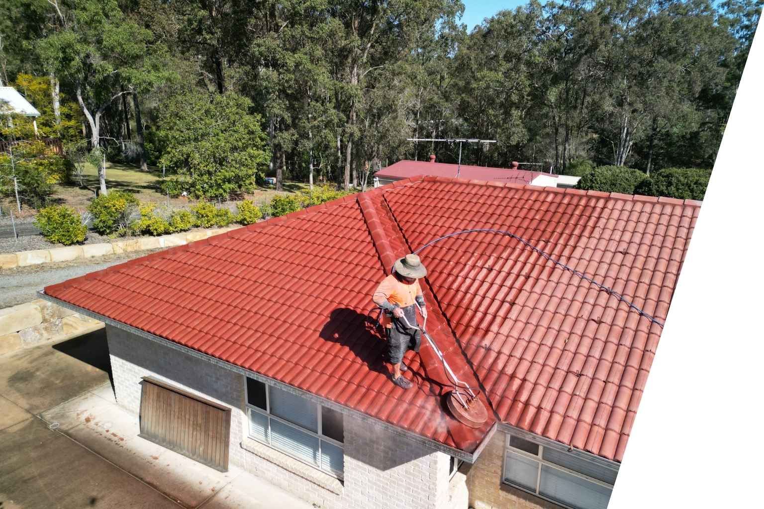 Red tiled residential roof undergoing restoration work in North Brisbane